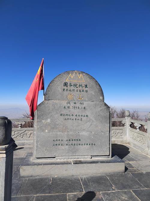 男子攀爬五岳独尊石,游客爬上五岳独尊石刻拍照